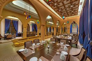 a restaurant with tables and chairs in a room at Ibiza The Fern Resort & Spa, Kolkata in Kolkata