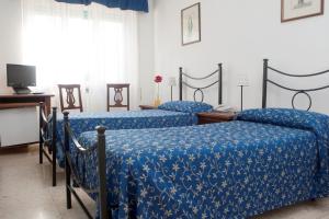 two beds in a room with blue comforter at Hotel Antico Acquedotto in Rome