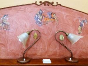 duas lâmpadas sobre uma mesa à frente de uma parede cor-de-rosa em Sun City em Kato Daratso
