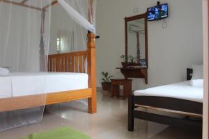 a bedroom with two beds and a mirror in it at Airport Green Hotel in Katunayake