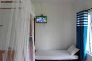 a room with a couch with a tv on the wall at Airport Green Hotel in Katunayake