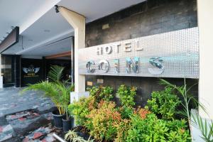 una señal para un hotel al lado de un edificio en Coins Hotel Jakarta, en Yakarta