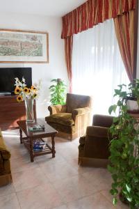 ein Wohnzimmer mit einem Sofa und einem Tisch mit Blumen in der Unterkunft Hotel Antico Acquedotto in Rom