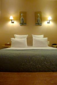 サントにあるCit'Hotel des Messageriesのベッドルーム1室(大型ベッド1台、枕、壁に鳥付)
