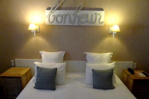 A bed or beds in a room at Cit'Hotel des Messageries