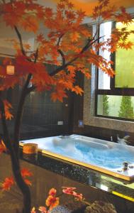 a jacuzzi tub in a room with a tree at Sunflower Motel in Hsinchu City