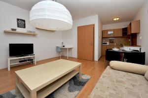 a living room with a table and a large light fixture at iHome Apartment 3.0 in Pécs