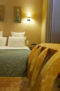 a hotel room with a bed with white pillows at Cit'Hotel des Messageries in Saintes