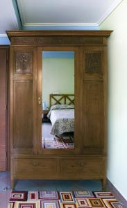 a wooden cabinet with a mirror in a bedroom at Akti in Nafpaktos
