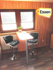 a kitchen with two bar stools and two windows at Ferienbungalow 1 in Dierkow