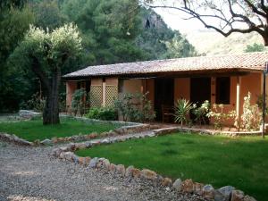 a house with a grass yard in front of it at Family Resort Cala di Luna in Marina di Camerota