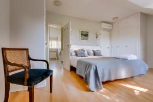 - une chambre blanche avec un lit et une chaise dans l'établissement House in Estoril, à Estoril