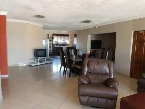 sala de estar con silla y comedor en Elilo Bed and breakfast, en Walvis Bay
