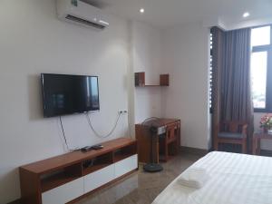 a room with a bed and a tv on the wall at Haengbok Hotel in Bắc Ninh
