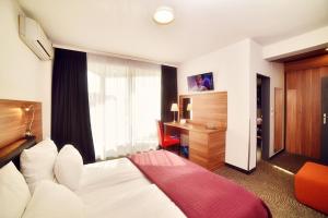 a hotel room with a bed and a television at Hotel President in Timişoara