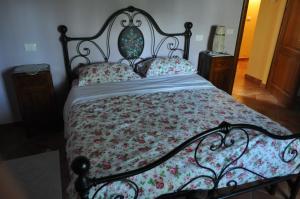 コルトーナにあるAgriturismo Dominus Domenicoの花柄のベッドカバーと枕が付いたベッド1台