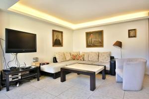 salon z kanapą i telewizorem z płaskim ekranem w obiekcie Portofino Apartment w mieście Sofia