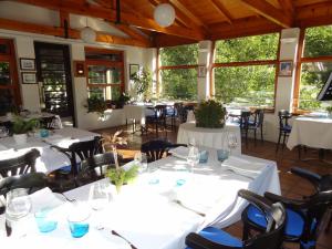 una sala da pranzo con tavoli e sedie bianchi di Hotel Restaurante Marroncín a Cangas del Narcea