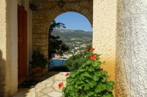 a building with an archway with a plant in a courtyard at Villa Polyxeni in Sivota