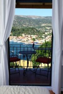 a room with a balcony with a table and chairs at Villa Polyxeni in Sivota