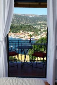 a room with a balcony with a table and chairs at Villa Polyxeni in Syvota