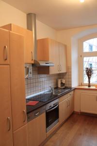 a kitchen with wooden cabinets and a stove top oven at Zum alten Landrat in Monschau