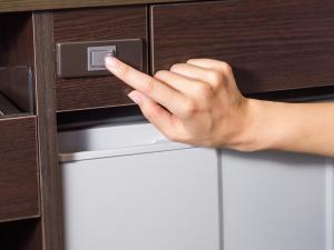 a hand is unlocking a cabinet with a drawer at APA Hotel Kyoto Ekikita in Kyoto
