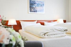 a bedroom with two beds with white pillows at Hotel Gasthaus Appel Krug in Delbrück