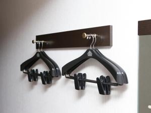 a wall mounted rack with black clothes hangers at APA Hotel Kyoto Ekikita in Kyoto