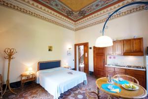 1 dormitorio con cama, mesa y cocina en Villa Teresa, en Porto Azzurro