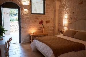 a bedroom with a bed and a table with candles at Masseria Grieco in Ostuni