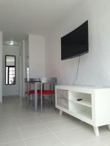 a living room with a tv on a white wall at Sun Luz Apartments 84 in Caleta De Fuste