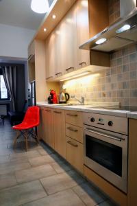 a kitchen with a stove and a red chair at Gazi Boutique Apartment 2 in Athens