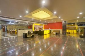 a lobby with a large lobby with chairs and tables at Cygnett Park Di-Arch in Lucknow