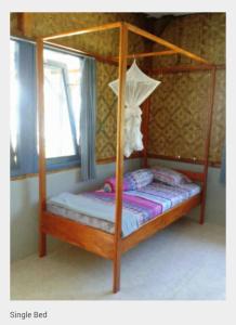 - une chambre avec un lit à baldaquin et une fenêtre dans l'établissement Leko Lembo Guesthouse, à Keli
