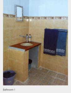 baño con lavabo y toalla azul en Leko Lembo Guesthouse, en Keli