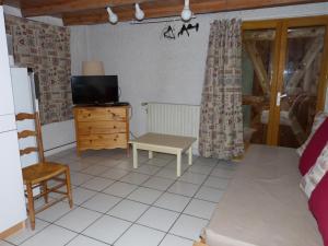 ein Wohnzimmer mit einem Sofa, einem TV und einem Tisch in der Unterkunft La Balme in Puy-Saint-Vincent
