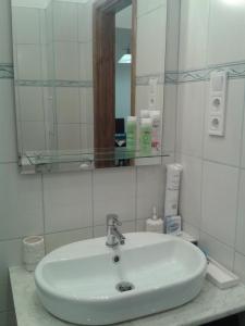 a white sink in a bathroom with a mirror at Lily apartman in Budapest
