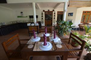a dining room table with purple candles on it at Sihilro Regency in Udawalawe