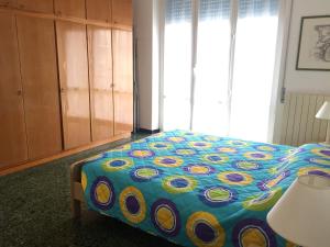 Un dormitorio con una cama con un edredón colorido. en Appartamento Roggero, en Levanto