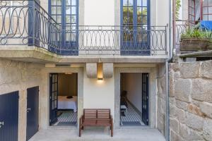 - un banc en bois installé sous un balcon dans un bâtiment dans l'établissement Casa Amarela, à Porto