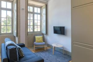 un salon avec un canapé bleu et une chaise dans l'établissement Casa Amarela, à Porto