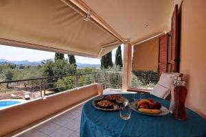 una mesa con un plato de comida en el balcón en Villa Figareto en Corfú