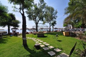 een park met een pad naar een strand met parasols bij Villa Figareto in Corfu-stad