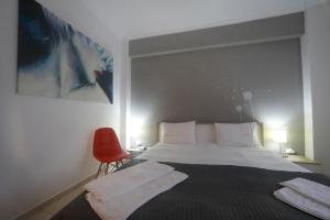 アテネにあるMetaxourghio Boutique Apartmentのベッドルーム1室(ベッド1台、赤い椅子付)