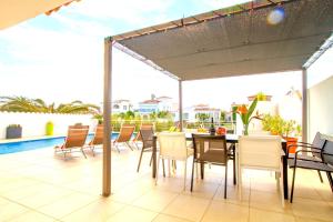 エンプリアブラバにあるLEON INMO Luxusvilla Esmeralda - 10029のパティオ(テーブル、椅子付)、プールが備わります。