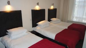 dos camas sentadas una al lado de la otra en una habitación en Sandyford Hotel, en Glasgow