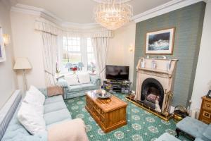a living room with a couch and a fireplace at Park Lodge Guest House in Whitley Bay