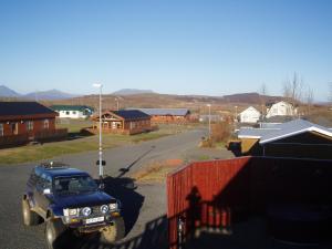 a blue truck parked on a street in a town at Húsid Guesthouse in Reykholt