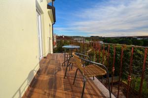 - un balcon avec deux chaises et une table dans l'établissement Stella Apartments, à Novigrad